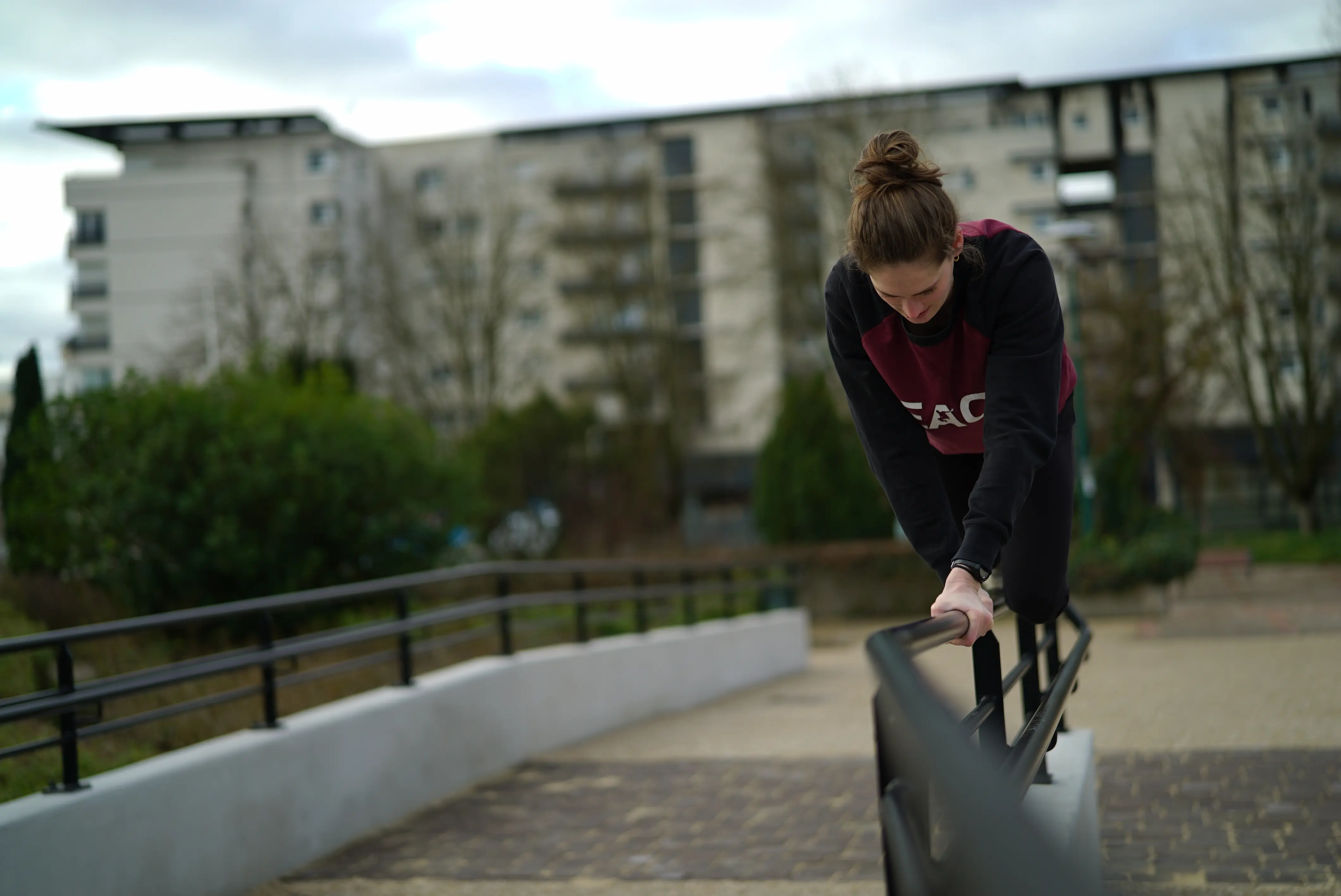 Pratiquante du Parkour réalisant une quadrupédie sur barre